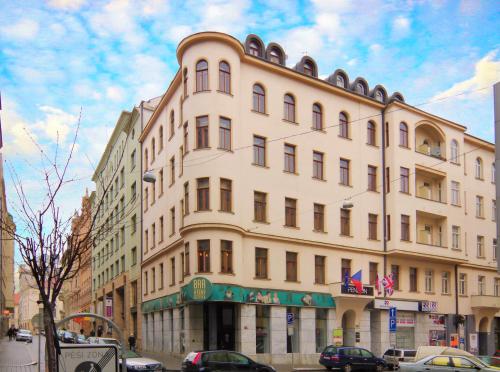 a large white building on a city street with cars at Penzion Dvořákova in Brno