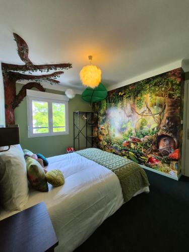 a bedroom with a large painting on the wall at L'évasion Cinégame - Gîte à thème in Diebolsheim
