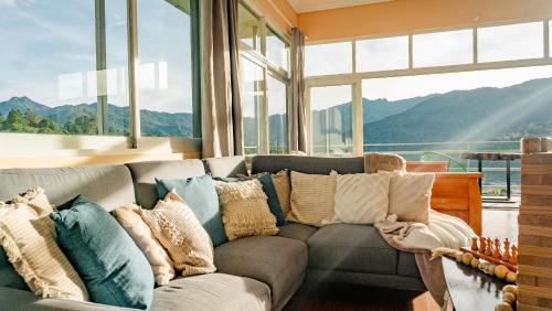 a living room with a couch and a large window at Casa Ejecutiva Boquete in Boquete