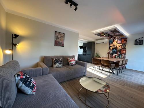 a living room with a couch and a table at L'évasion Cinégame - Gîte à thème in Diebolsheim