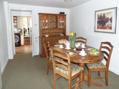 Un comedor con mesa y sillas de madera. en Gracedieu, en Killin