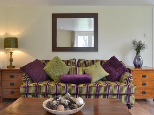 a living room with a couch and a mirror at Tiptoe in Steeple Ashton