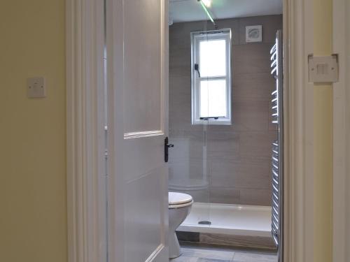 a bathroom with a shower and a toilet and a tub at Tiptoe in Steeple Ashton