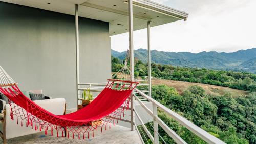 a hammock on a balcony with a view of the mountains at Casa Ejecutiva Boquete in Boquete