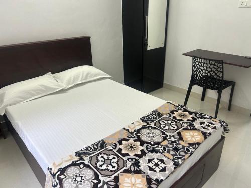 a bed in a room with a table and a chair at Samriddhi Homestay in Trivandrum