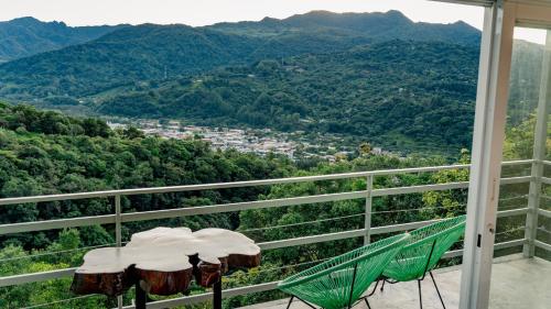 a balcony with two chairs and a view of the mountains at Casa Ejecutiva Boquete in Boquete
