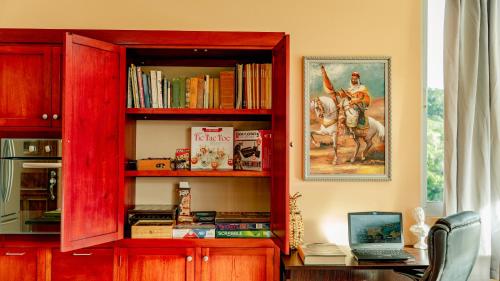 a red book shelf with a desk with books at Casa Ejecutiva Boquete in Boquete