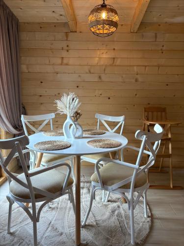a table and chairs in a room with a wooden wall at Wooden House Šapat sela in Podgorica