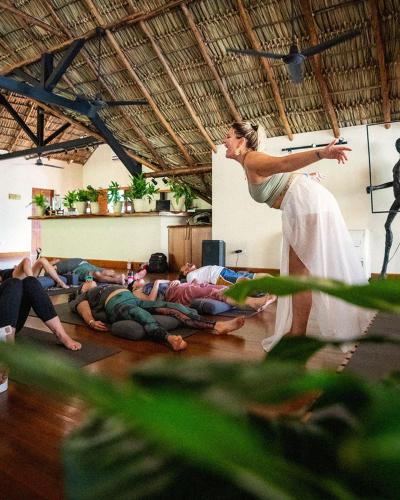 a woman standing over a group of people laying on the floor at TreeCasa Hotel & Resort Nicaragua in San Juan del Sur