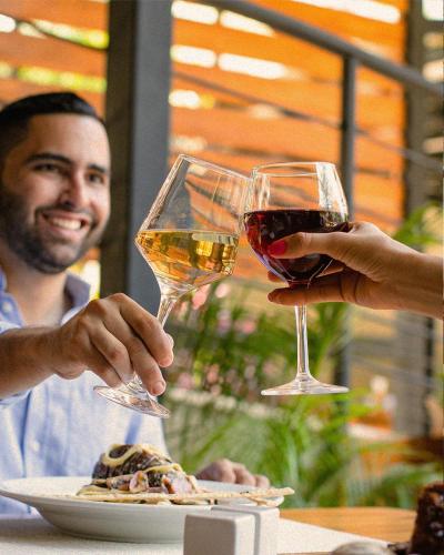 two people holding glasses of wine at a table at TreeCasa Hotel & Resort Nicaragua in San Juan del Sur