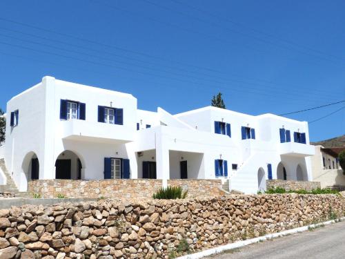 a white house with a stone wall at Ioli Apartments in Alopronia