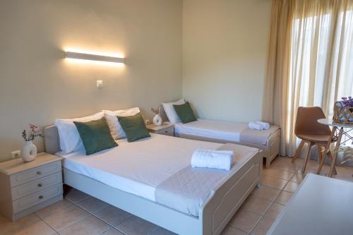a bedroom with two beds and a table at Filoxenia Apartments in Mytilini