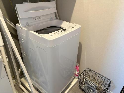 a white washer and dryer in a room at Crest Blue 404-オーシャンフロント! 新築マンション! in Kin