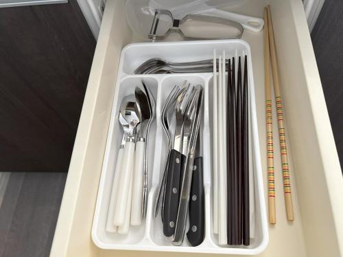 a white tray filled with utensils in a drawer at Crest Blue 404-オーシャンフロント! 新築マンション! in Kin