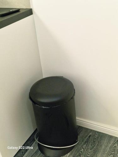 a black trash can in the corner of a room at RentA Citywalk Flat in Kaunas