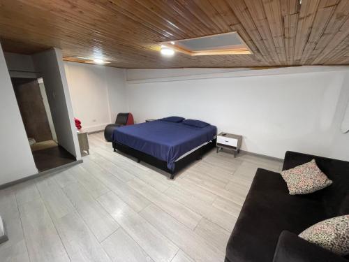 a bedroom with a bed and a couch at Hostel Titan Plaza Cll 80 in Bogotá