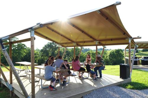a group of people sitting in a gazebo at The Lodges at Eden Reserve - Cabin Loop - Near Ark in Williamstown