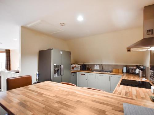a kitchen with a table and a refrigerator at Ptarmigan Lodge in Balmaha
