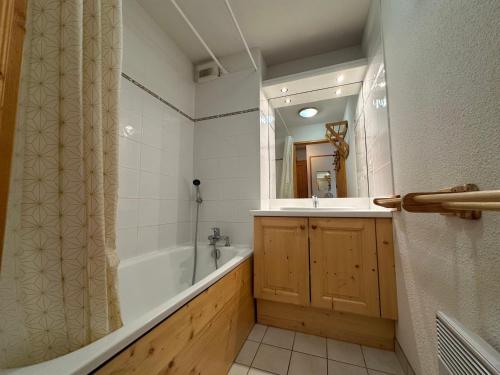 une salle de bain avec une baignoire, un lavabo et un miroir dans l'établissement Appartement cosy pour 6 personnes au pied des pistes à Morillon 1100 - FR-1-642-27, à Morillon