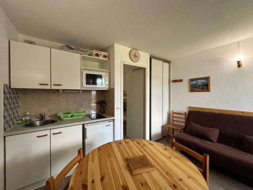 Il comprend une cuisine et un salon avec une table en bois. dans l'établissement Appartement cosy 4-5 pers. skis aux pieds à Morillon 1100 - FR-1-642-31, à Morillon
