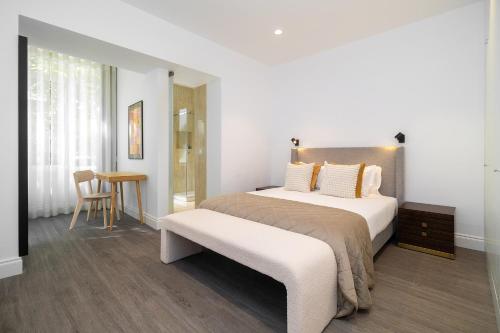a bedroom with a large bed and a table at WHome Stylish Oasis near Parque Eduardo VII in Lisbon