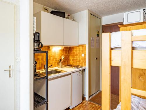 une petite cuisine avec des armoires blanches et un évier dans l'établissement Studio cosy 19m² pour 3 pers, proche pistes et commerces, Saint-François-Longchamp - FR-1-807-57, à Saint-François-Longchamp