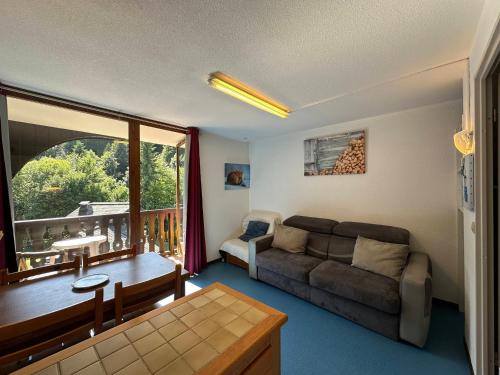 d'un salon avec un canapé et un balcon. dans l'établissement Studio cosy 4 pers. au pied des pistes à Morillon 1100, balcon exposé ouest - FR-1-642-75, à Morillon