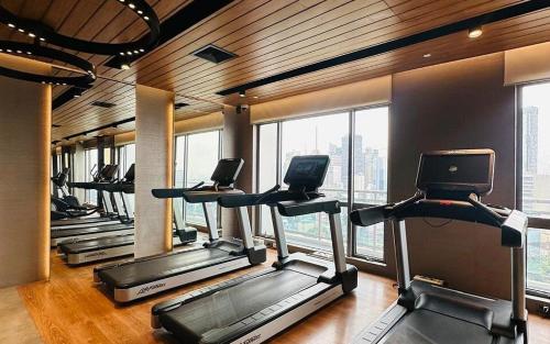 a row of treadmills in a gym with windows at Acqua at The Hotel Residences Acqua Manila near Makati and BGC in Manila
