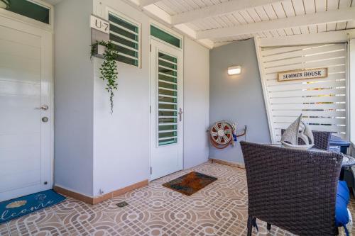 a porch with a white door and a table and chairs at Dorado Del Mar Villa by PH in Dorado