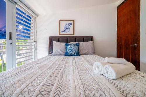 a bedroom with a large bed with towels on it at Dorado Del Mar Villa by PH in Dorado