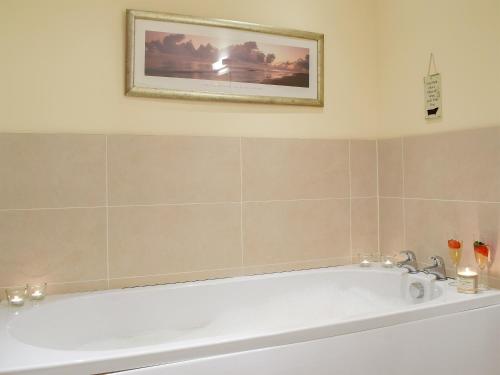 a bath tub in a bathroom with a picture on the wall at Frith View in White Bridge