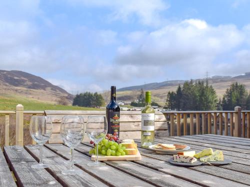 a wooden table with two bottles of wine and wine glasses at Frith View in White Bridge