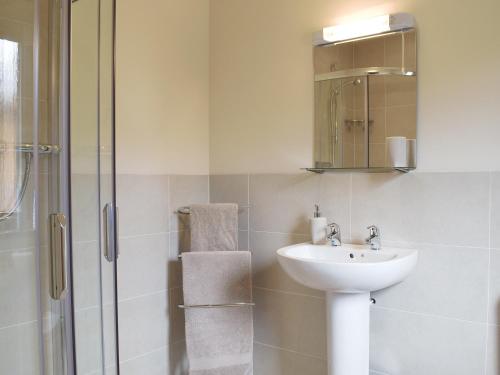 a white bathroom with a sink and a shower at Frith View in White Bridge