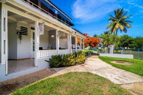 a white house with a palm tree in the background at Dorado Del Mar Villa by PH in Dorado