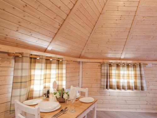 a wooden dining room with a table and chairs at Little Luxe Lodges 2 in Coillemore