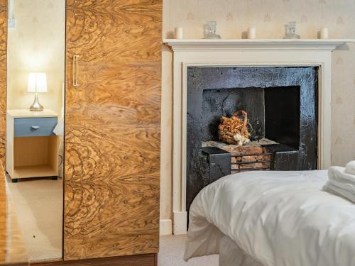 a bedroom with a wooden door with a fireplace at Number 4 in Llandeilo