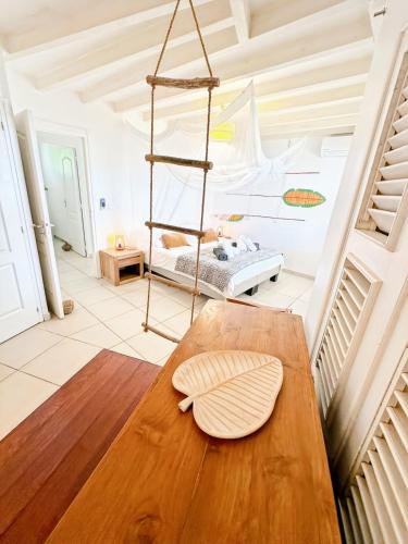 a living room with a wooden table and a bed at Villa Lauréal in Grand-Bourg