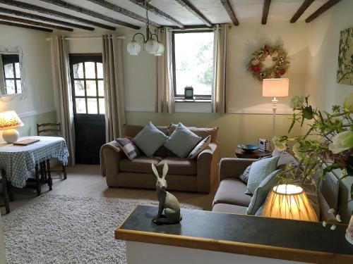 ein Wohnzimmer mit Sofa und Tisch in der Unterkunft Little Beck in Troutbeck