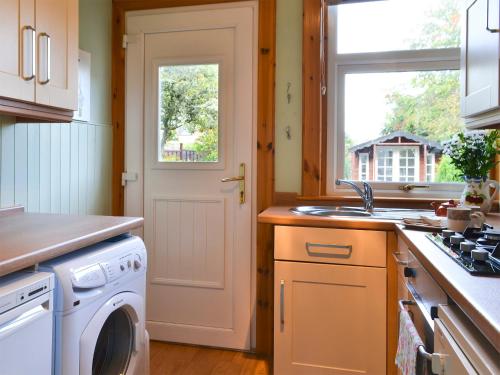a kitchen with a washing machine and a sink at Viewhill Villa in Inverness