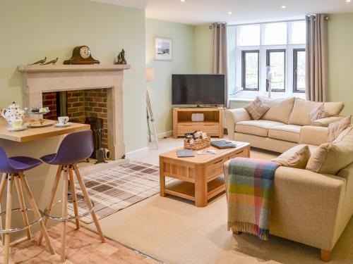 a living room with a couch and a fireplace at Addycombe Cottage in Rothbury