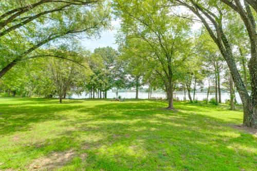 a park with trees and a lake in the background at 7 and Acre Private Waterfront Gem in Colonial Beach in Colonial Beach