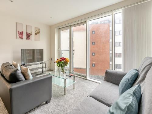 スウォンジーにあるApartment 13のソファとガラスのテーブルのあるリビングルーム