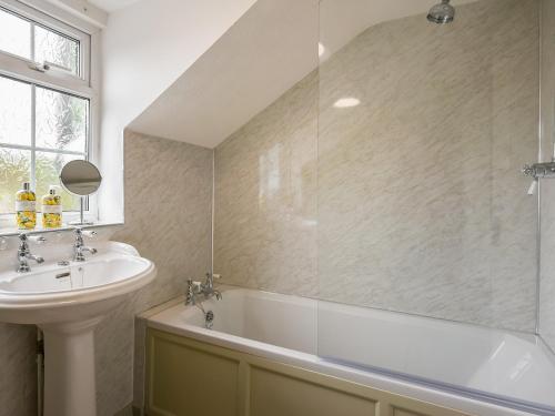 a bathroom with a sink and a bath tub next to a window at Dolwen Isaf in Llangadfan