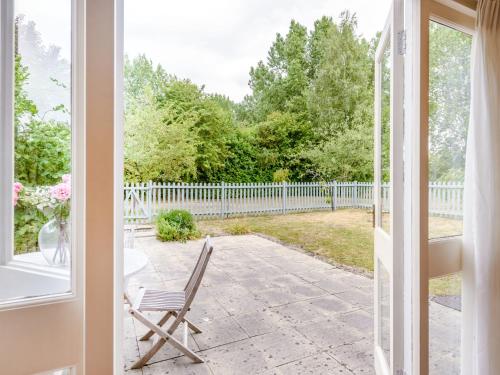 a chair sitting on a patio outside a window at Coach House - Uk33307 in Mellis