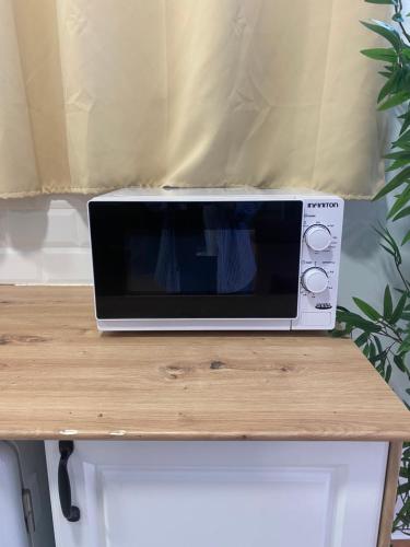 a microwave sitting on top of a wooden table at ALZIRA BONITA APARTAMENTO CON TERRAZA Y JACUZZi EXTERIOR in Alzira