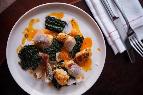 a plate of food with vegetables on a table at Artist Residence Bristol in Bristol
