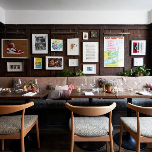 a restaurant with wooden walls and tables and chairs at Artist Residence Bristol in Bristol