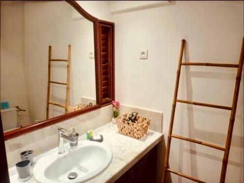 a bathroom with a sink and a mirror at Résidence TARTANE - Apt ZANDOLI - Vue Mer in La Trinité
