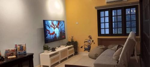 a living room with a couch and a flat screen tv at Minions In The Hills in Bentong