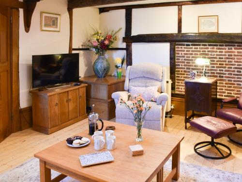 a living room with a table and a tv at The Old Workshop in Great Yarmouth